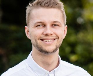 Picture of man looking into the camera smiling.
