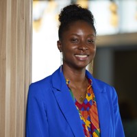 woman, wearing a bright blue blazer, smiling