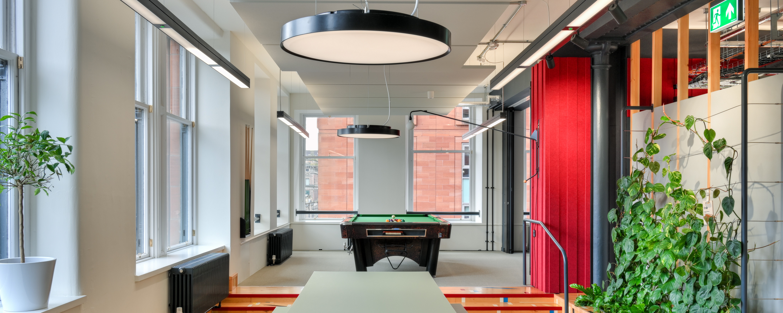 Office space with pool table, green table and green plants
