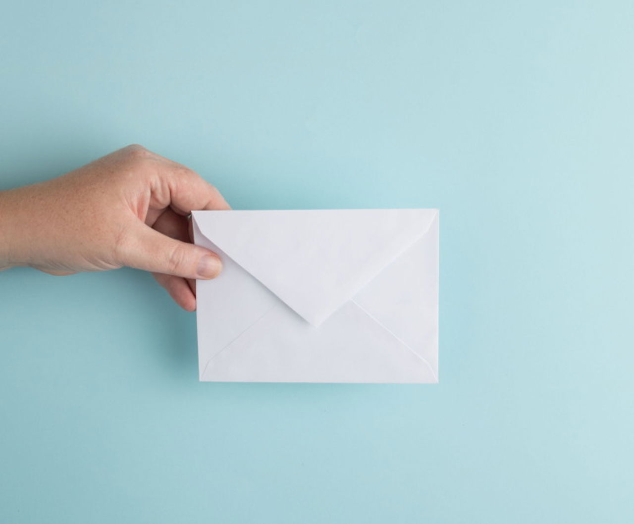 Hand holding a white envelope